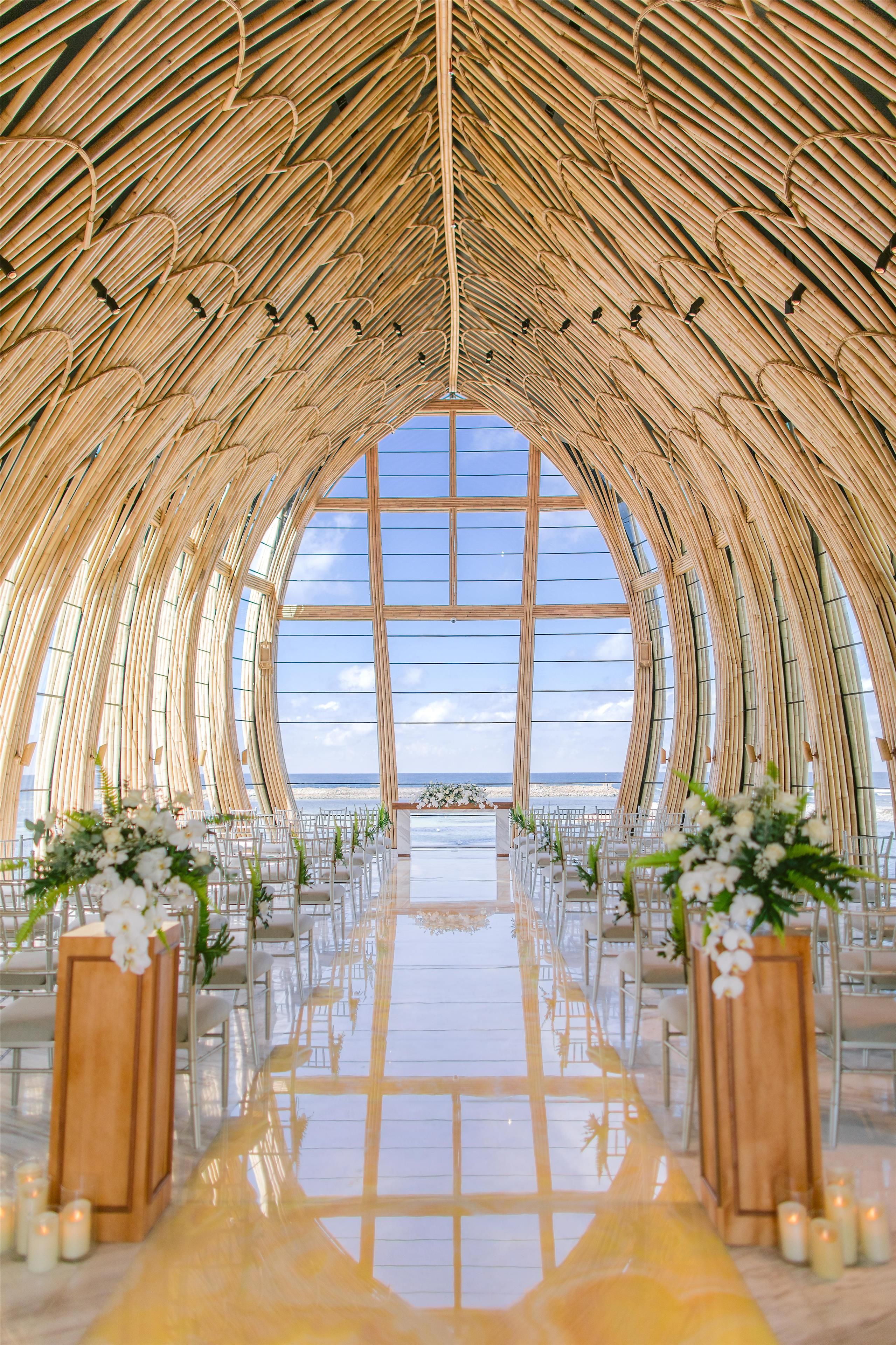 An arched structure with a reflective floor and a view of the beach.