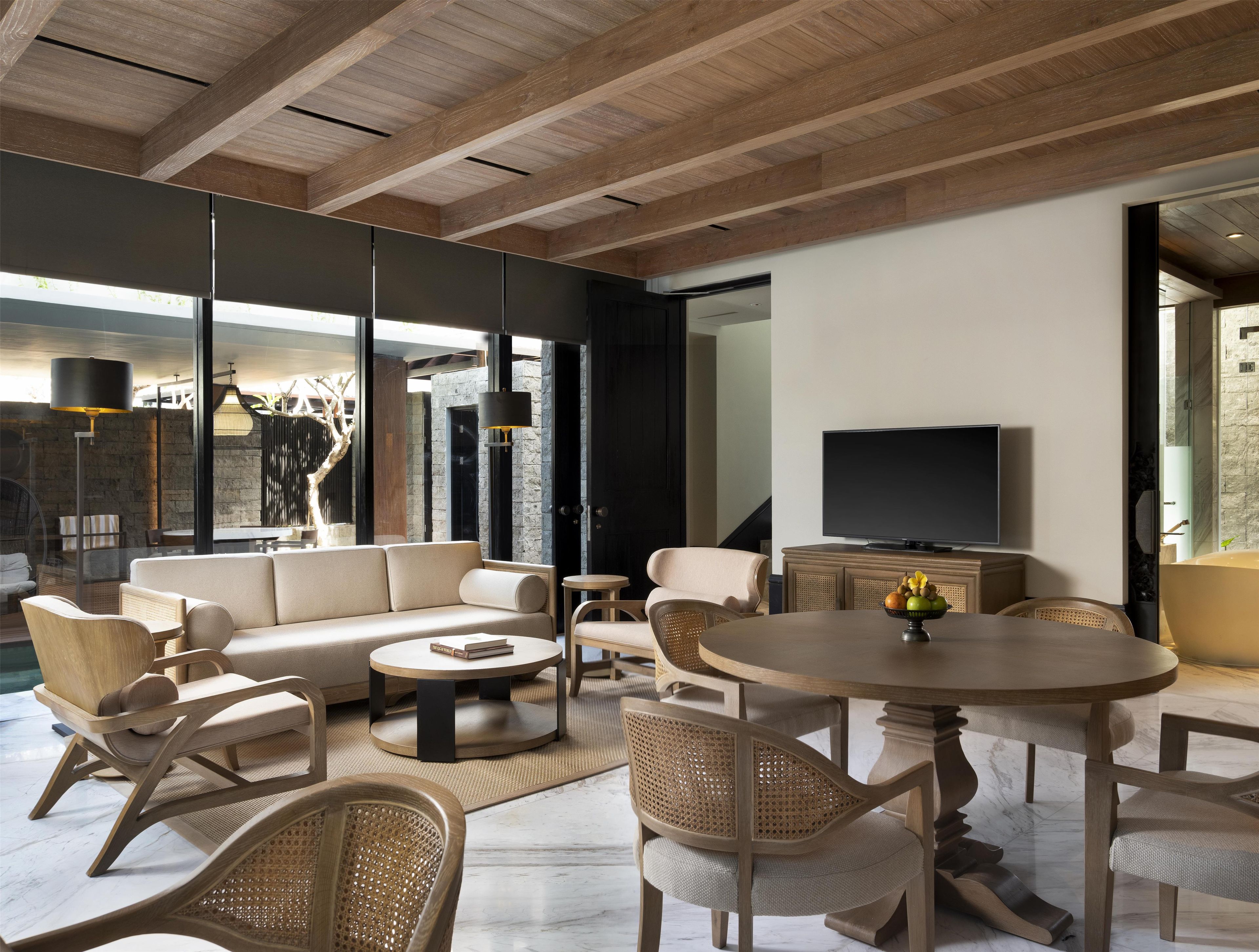 A modern living room with a sofa, chairs, a coffee table, and a television.