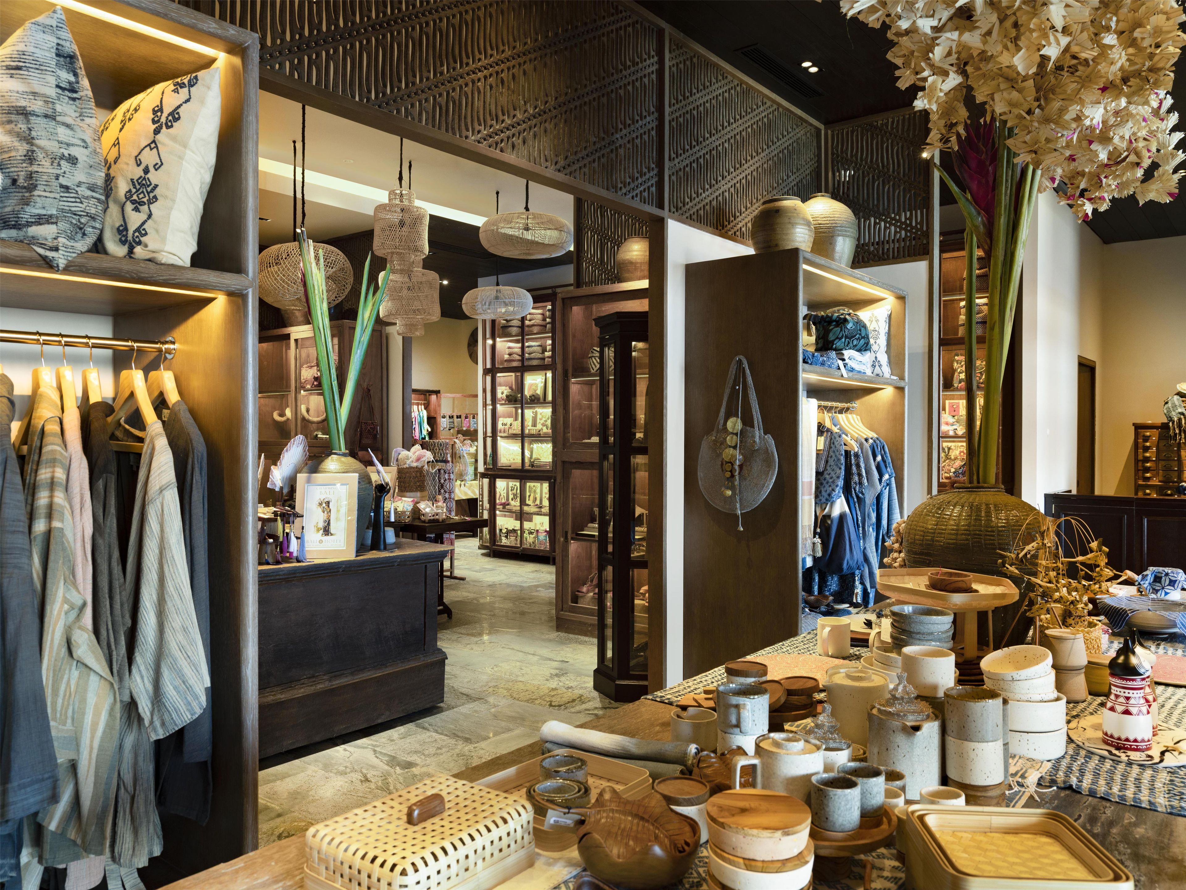 A boutique hotel interior with a variety of home decor items, including textiles, pottery, and hanging lamps.