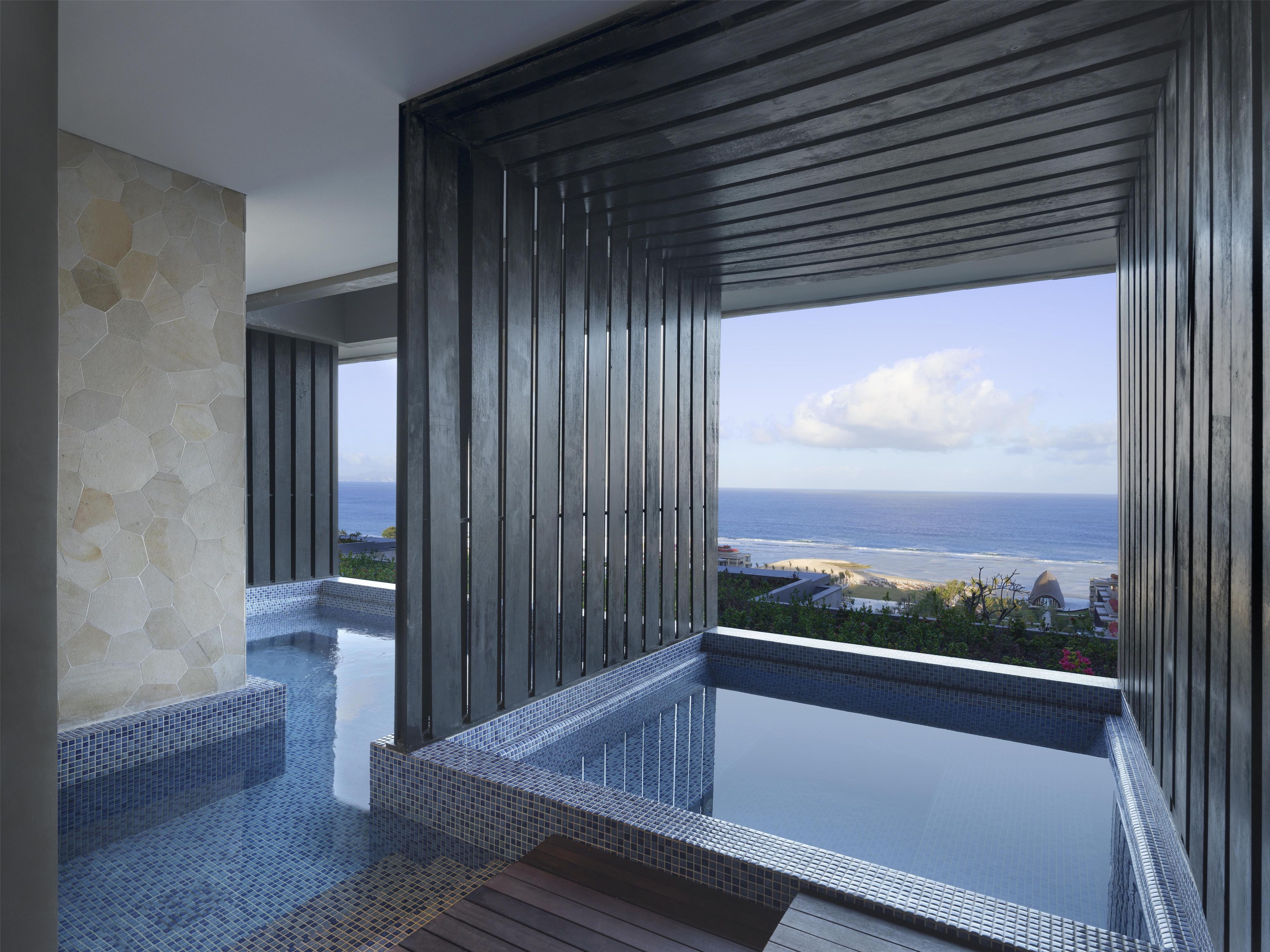 Ein moderner Infinity-Pool mit freiem Blick auf das Meer und den Strand.