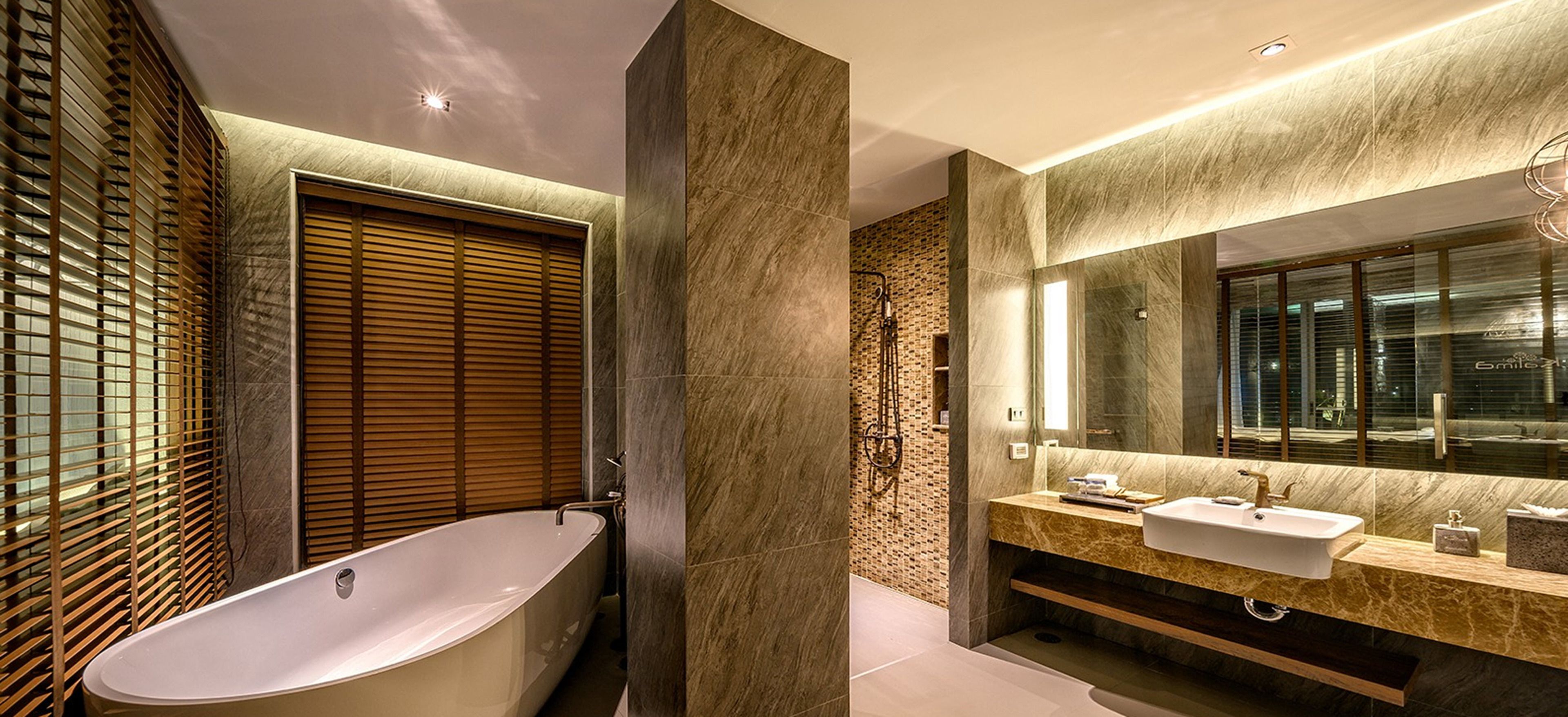Un baño moderno con una bañera independiente, un lavamanos con espejo y una zona de ducha.
