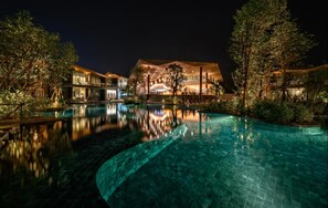 A modern hotel with a large pool, reflecting the building and surrounding trees. - Kalima Resort & Villas Khaolak (Thai Mueang)