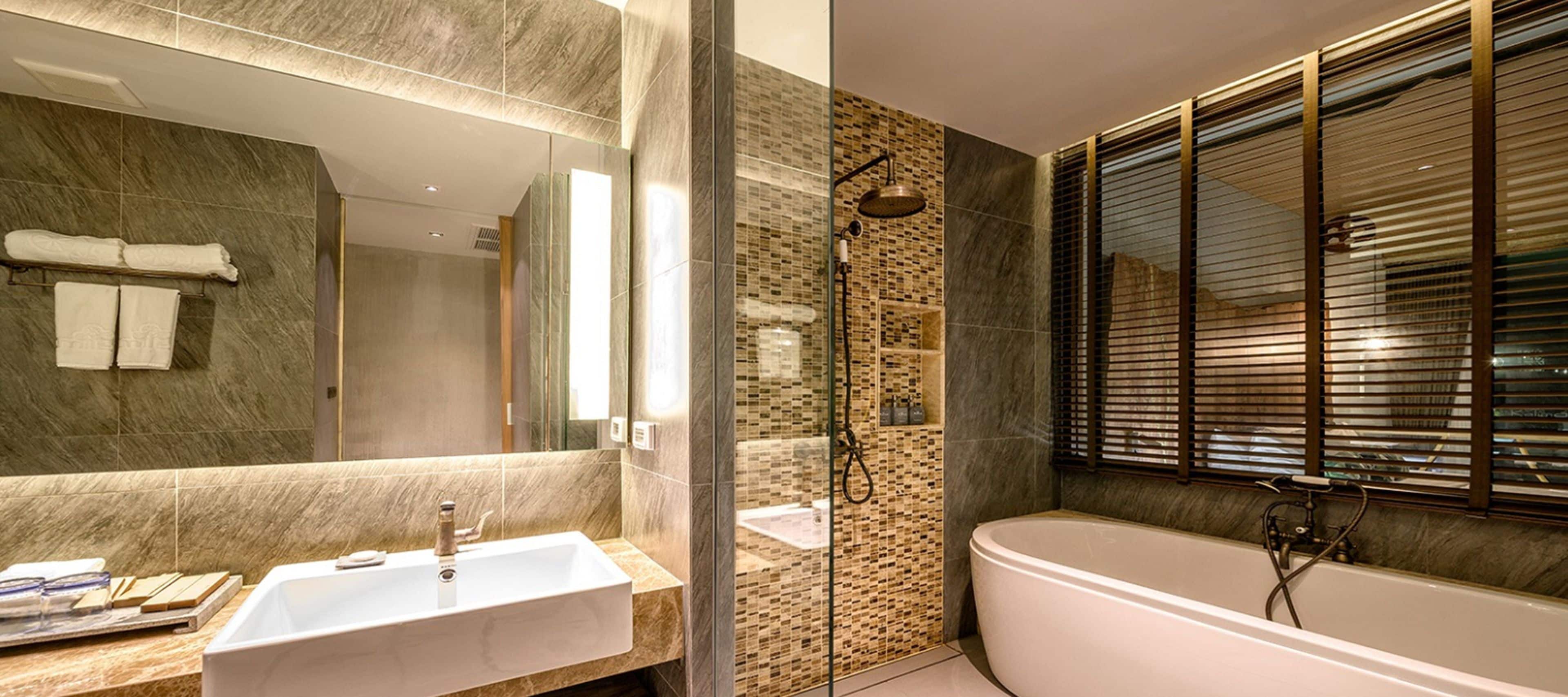 Een moderne badkamer met een vrijstaand bad, een douche met glazen wanden en een grote spiegel boven de wastafel.