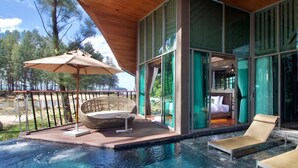 A modern outdoor pool area with lounge chairs, a wicker chair, and a large umbrella. - Kalima Resort & Villas Khaolak (Thai Mueang)