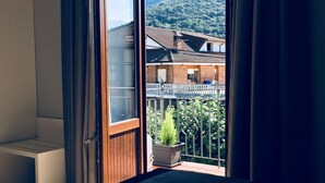 Ein Zimmer mit einer großen Schiebetür und einem Balkon mit Blick auf die Berge.