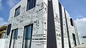 A modern building with a unique facade featuring geometric cut-out patterns.