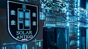 A hotel entrance with a neon sign reading "SOLAR ANTIGO PORTO".