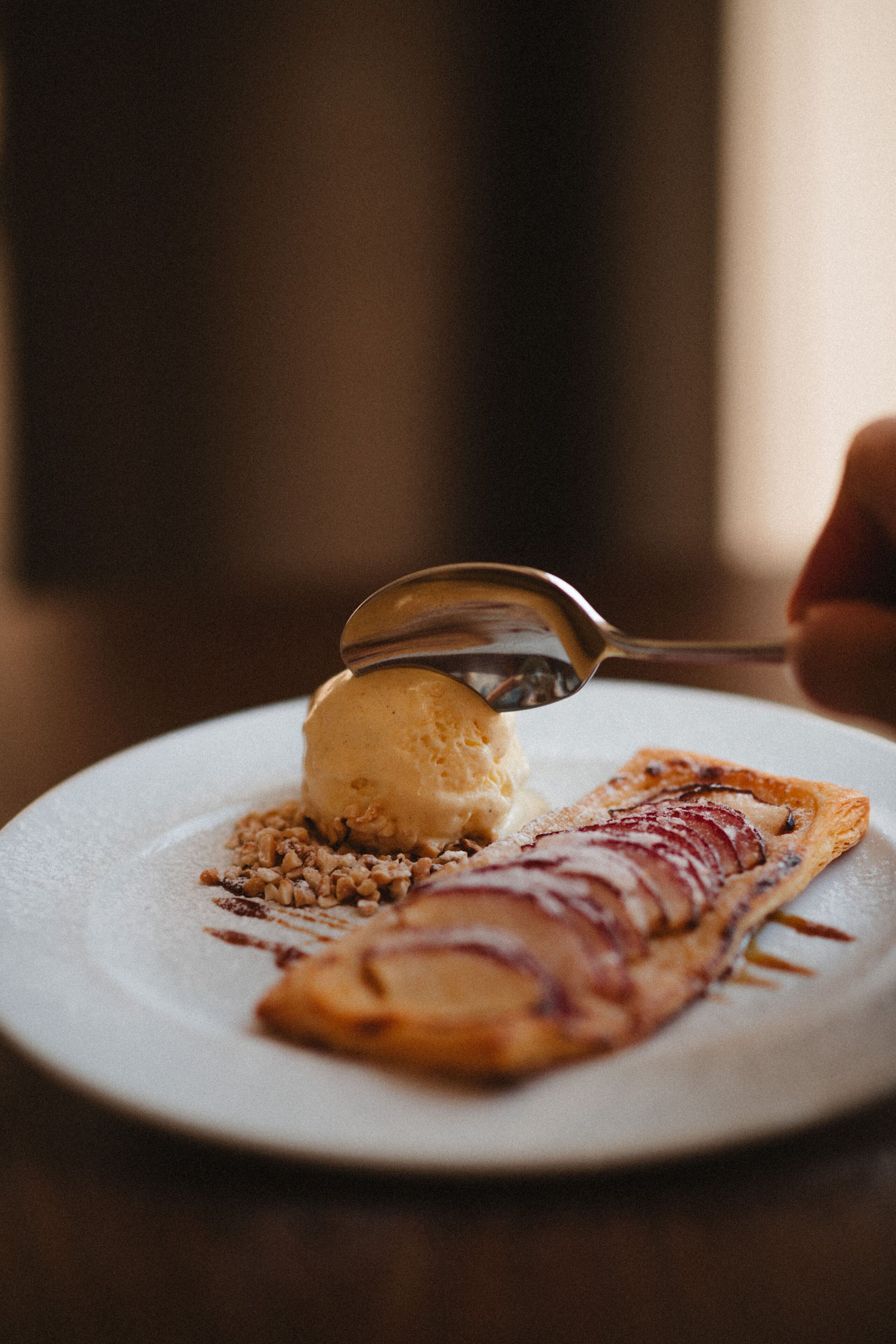 Un plato con helado y un pastel sobre una vajilla blanca.