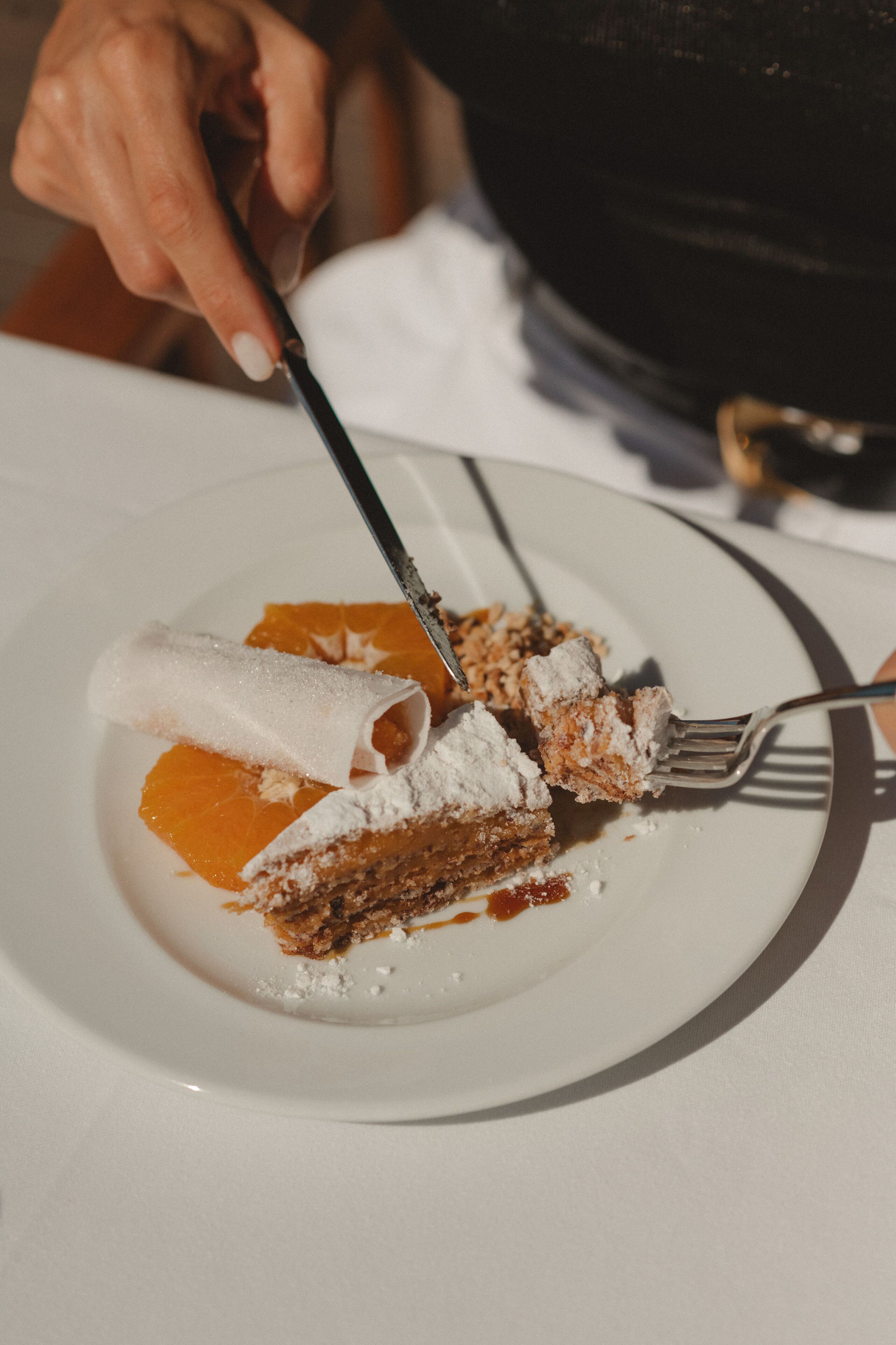 A plate with a slice of cake and a rolled pastry on a white plate.
