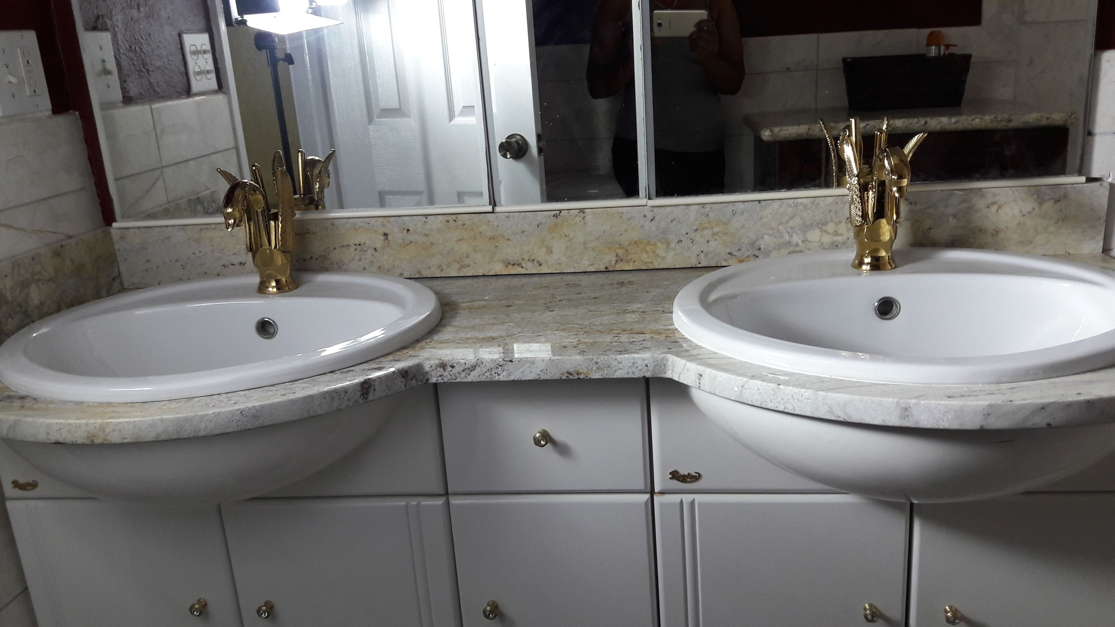 A bathroom with two sinks, a mirror, and a countertop.