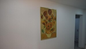 Un pasillo con un cuadro de girasoles en la pared.