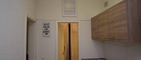 A kitchen with wooden cabinets, a stove, and a sign that says "KEEP CALM AND CARRY ON".