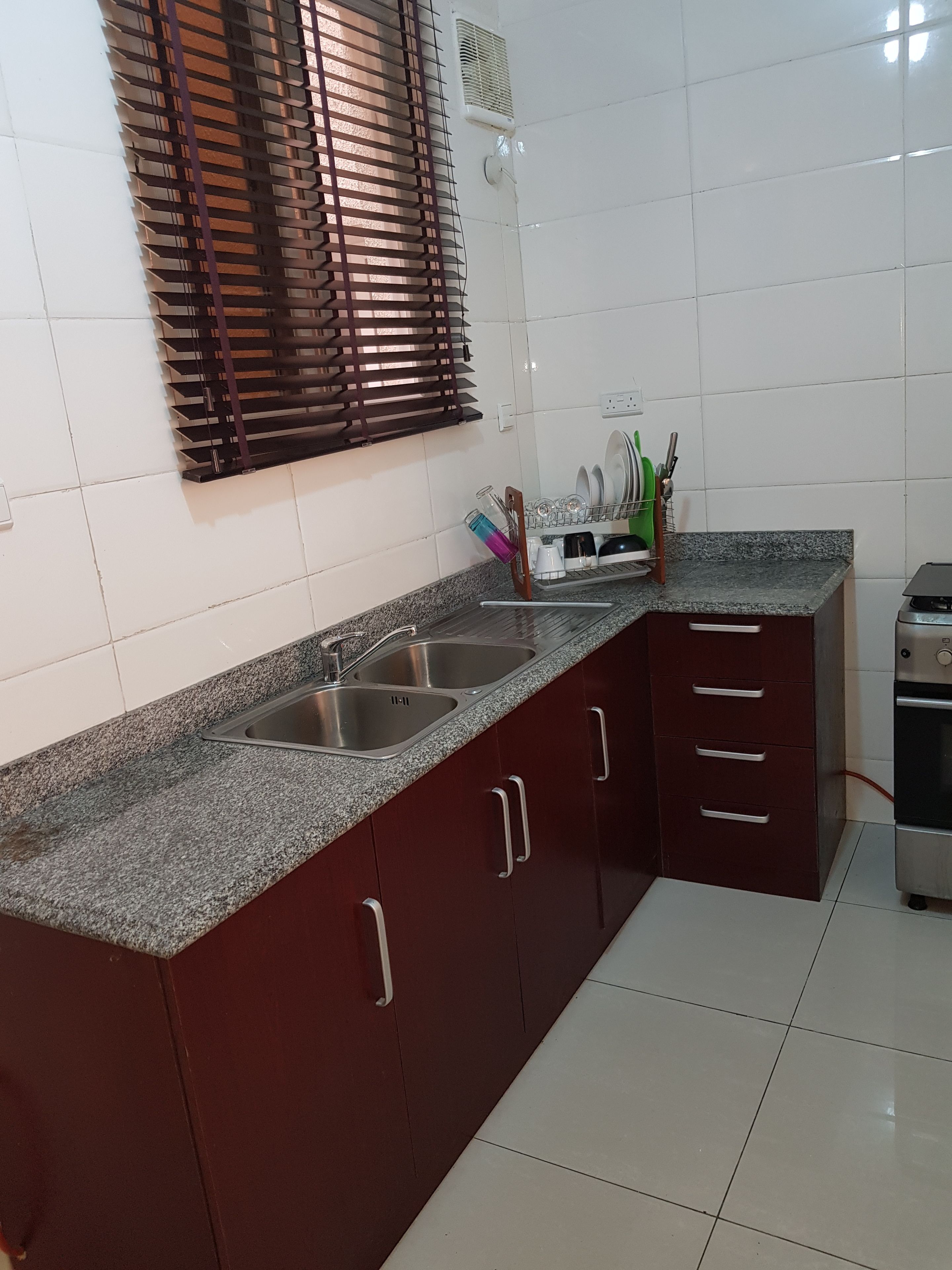 Una cucina con piano di lavoro in granito, lavello in acciaio inossidabile e forno integrato.