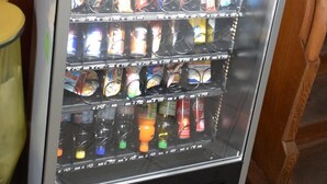 A vending machine with a selection of beverages and snacks.