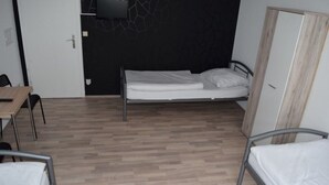 Een kamer met een bed, een bureau en een stoel.