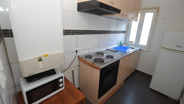 A compact kitchen with a stove, microwave, and a window. - AB Apartment 15 (Stuttgart)