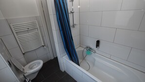 A bathroom with a white toilet, a bathtub, and a shower. - AB Apartment 15 (Stuttgart)