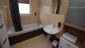 Une salle de bain avec une baignoire, un lavabo et un miroir.