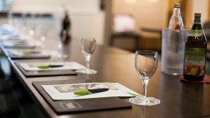 A dining table with wine glasses, water bottles, and menus. - Landhotel Laarmann (Lennestadt)