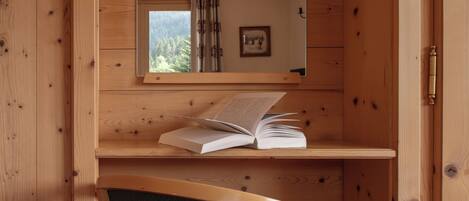 Una habitación de cabaña de madera con escritorio, silla y espejo.