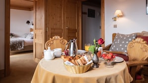 A breakfast table with bread, a pitcher, and a bowl of strawberries. - Le Chamois d'Or (Cordon)