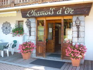 A wooden storefront with a sign reading "Chamoi's d'Oe". - Le Chamois d'Or (Cordon)