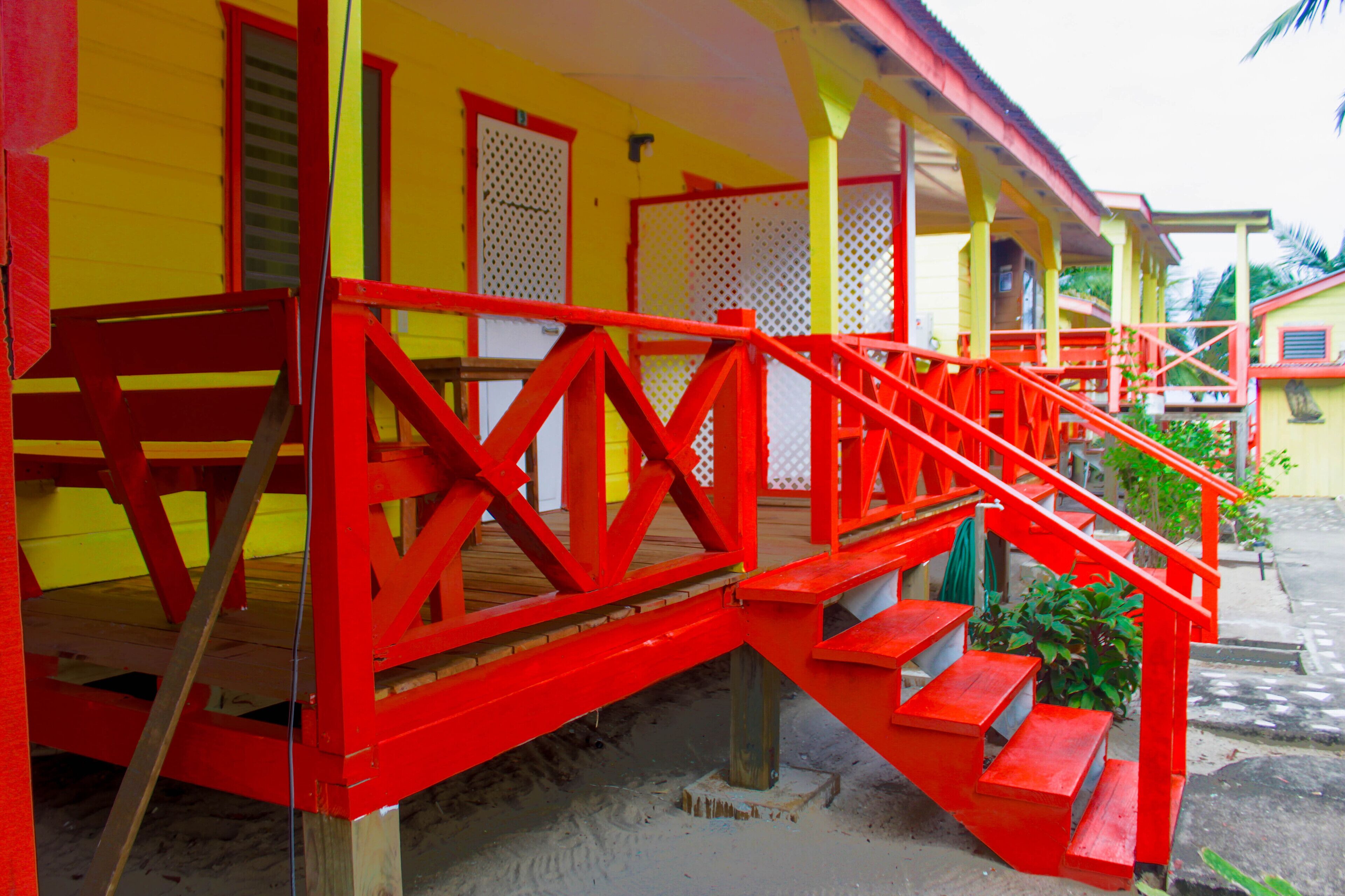 Un bâtiment aux couleurs vives, avec un escalier rouge menant à un porche.
