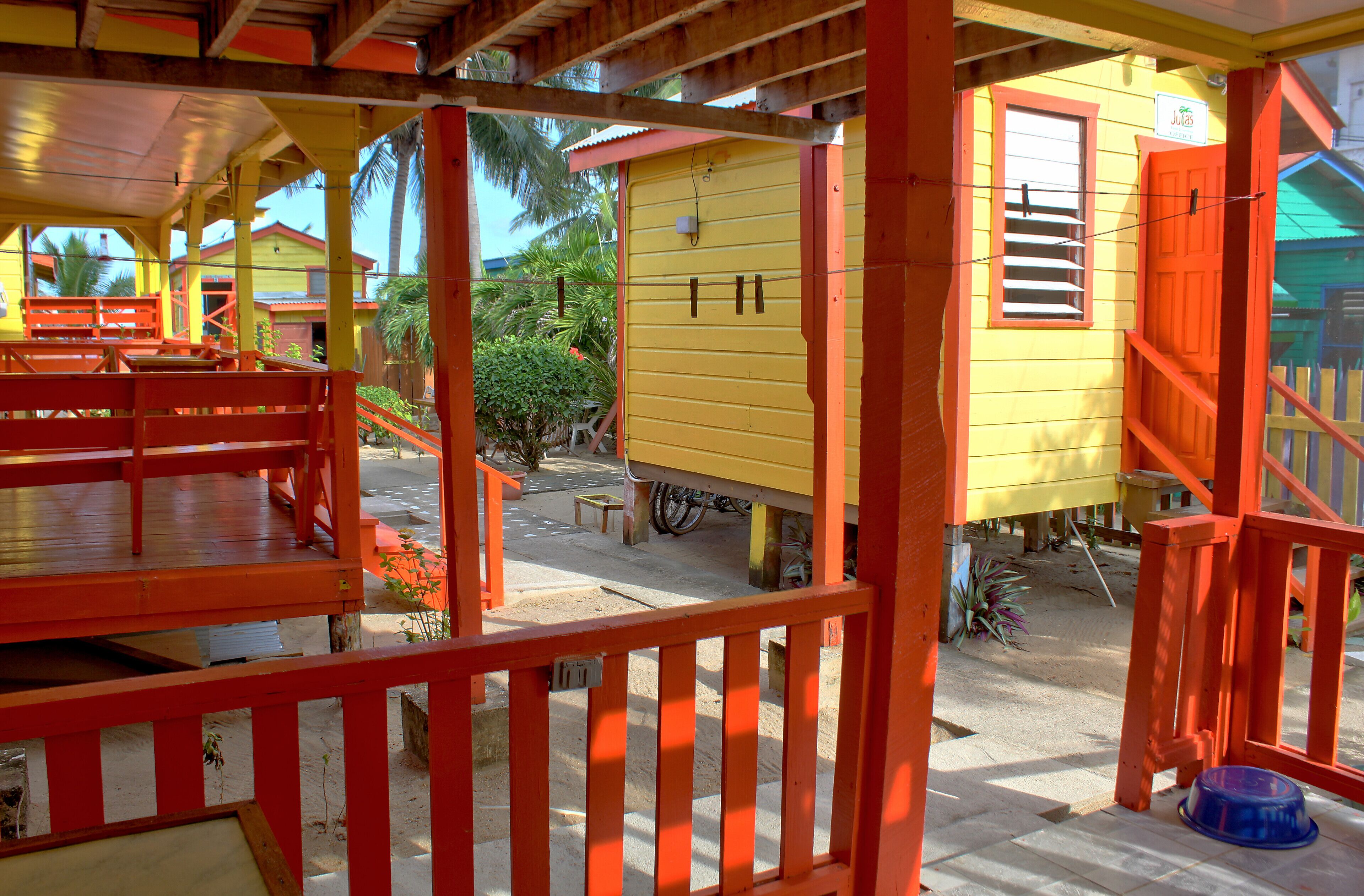A yellow building with a red railing and a blue bowl on the ground.