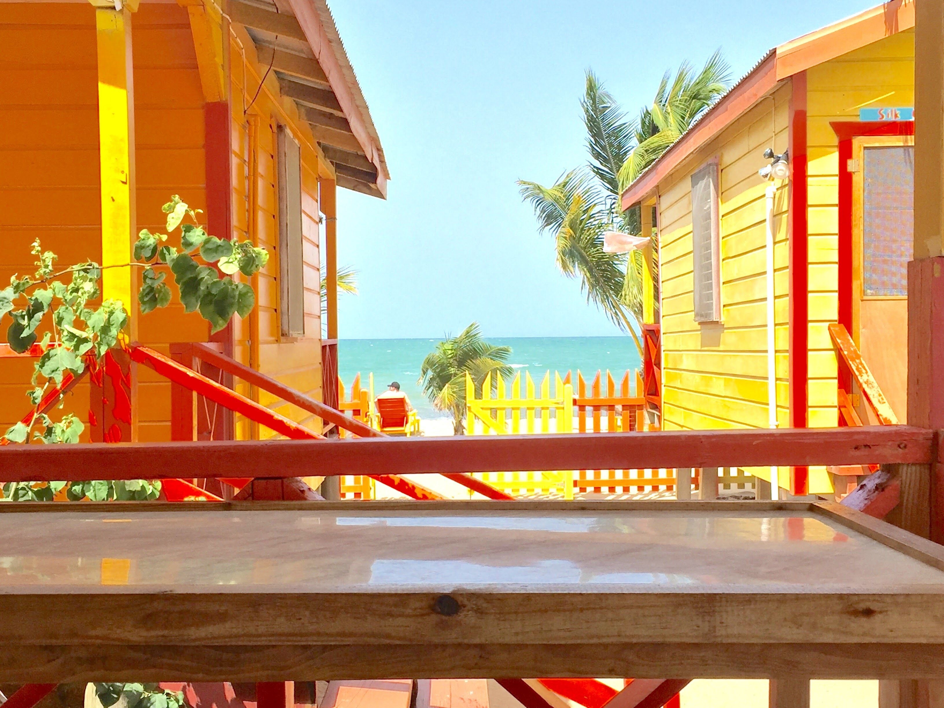 A wooden deck with a view of the beach and ocean.