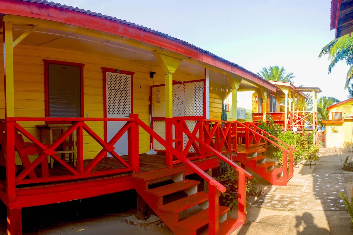 A yellow building with red railings and a staircase.