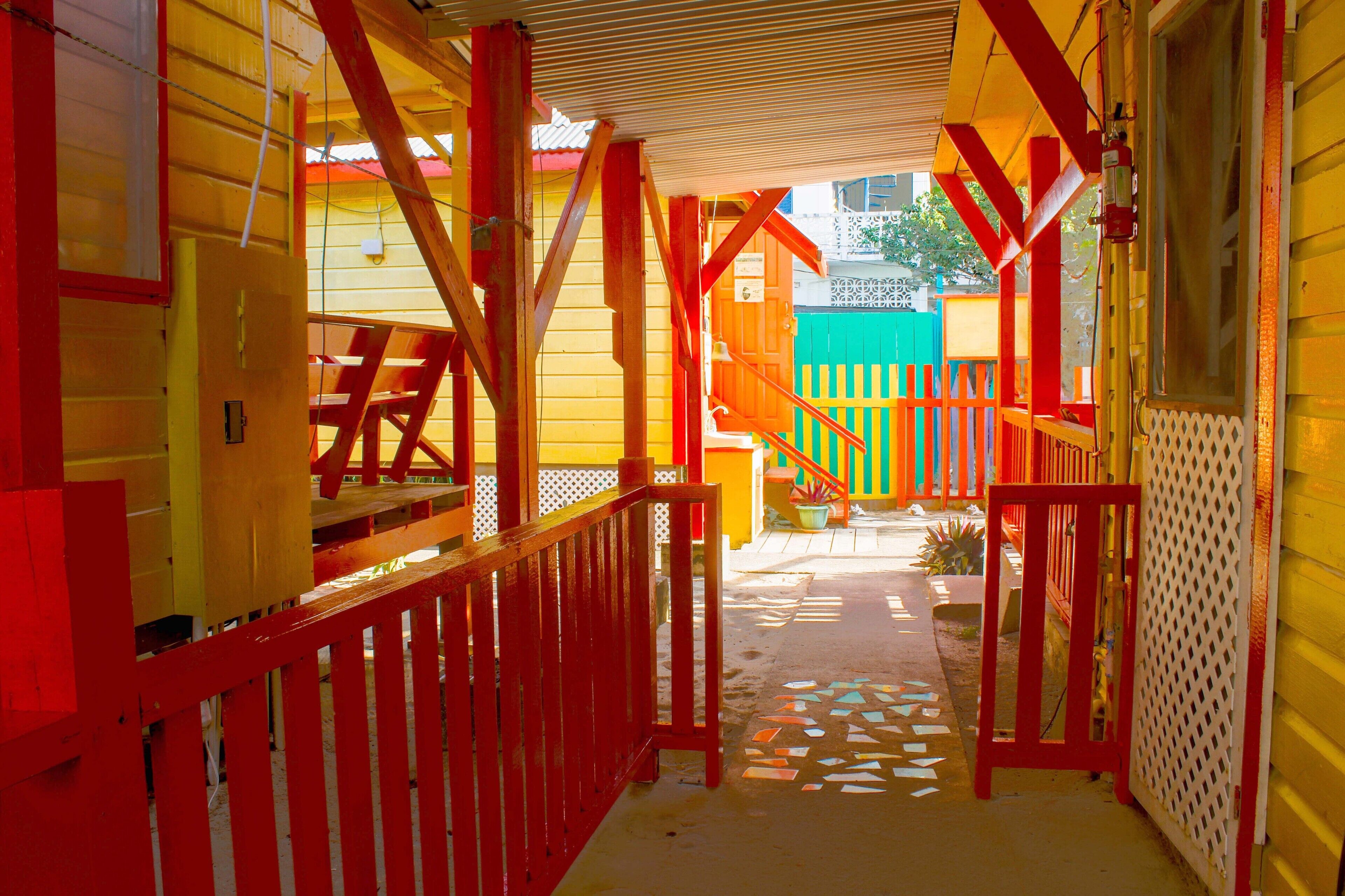 A brightly colored wooden structure with a red railing and a white lattice panel.