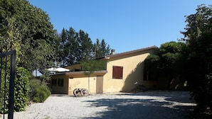 A two-story building with a gravel driveway and a bicycle parked in front. - Agriturismo La Selva (Nocera Umbra)
