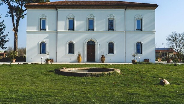 A two-story building with a symmetrical facade, arched windows, and a central entrance. - Villa Archi (Faenza)