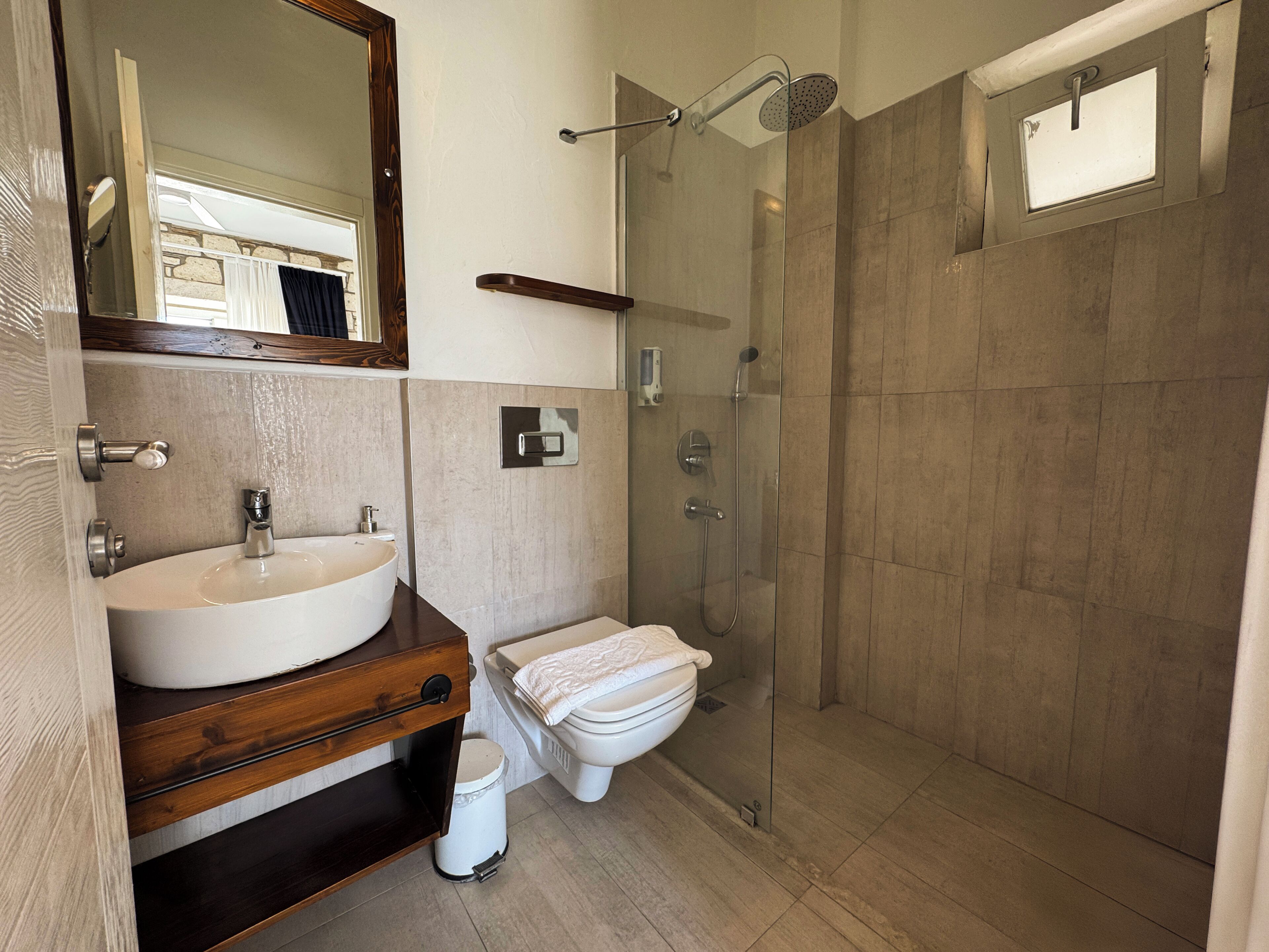 Une salle de bain moderne avec un grand lavabo, des toilettes et une douche à parois de verre.