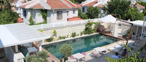 A poolside area with outdoor seating and a view of surrounding buildings.