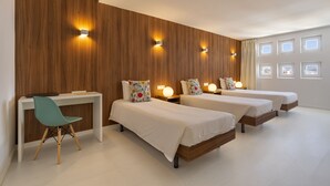A hotel room with two beds, a desk, and a chair.