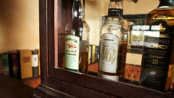 A selection of whiskey bottles in a wooden cabinet.