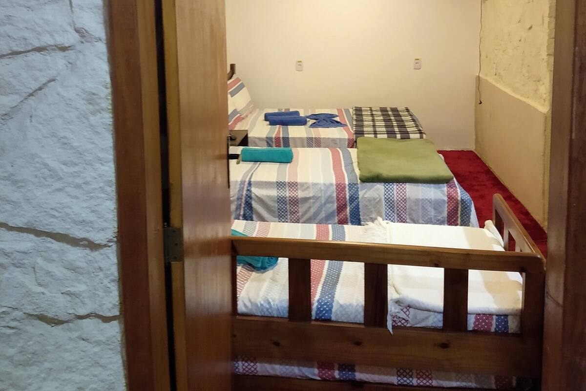 Una habitación con literas, un televisor montado en la pared y un marco de puerta de madera.