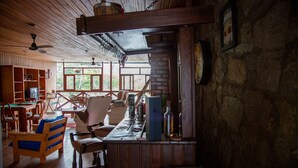 Un interior rústico de madera con barra, mobiliario de madera y paredes de piedra.
