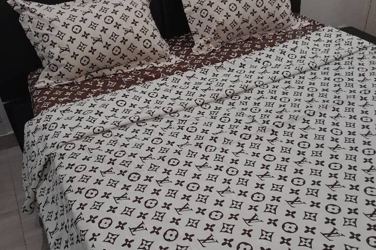 Una cama con una colcha estampada y almohadas a juego.