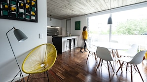 A modern interior with a dining area, kitchen, and large windows. - PortoSoul Trindade (Porto)