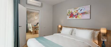 A hotel room with a bed, a desk, and a chair.
