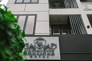 Une enseigne d’hôtel ornée d’un blason et portant le nom « Boutique Hotel ».