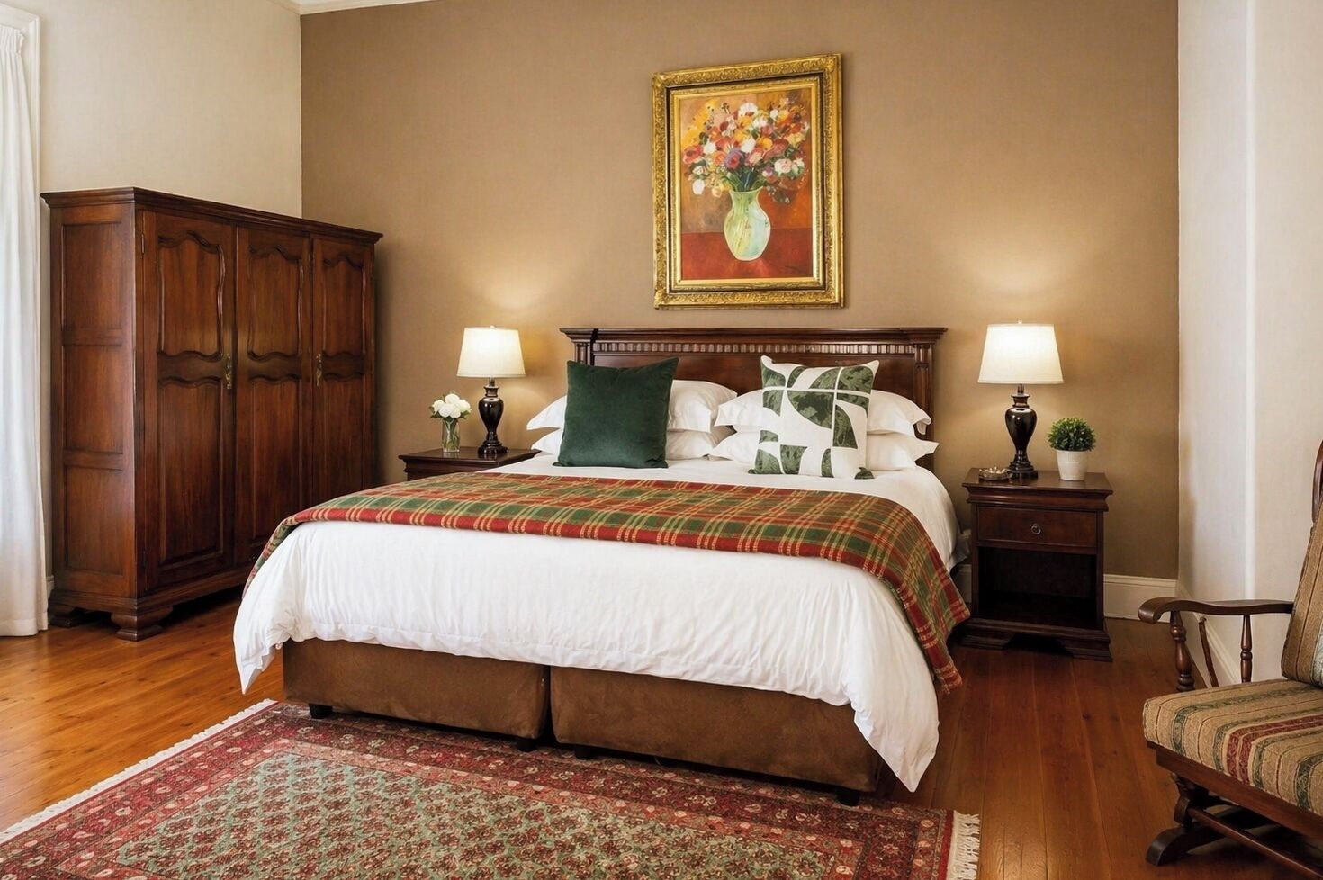 A bedroom with a large bed, two bedside tables with lamps, a wooden wardrobe, a painting on the wall, and a patterned rug.