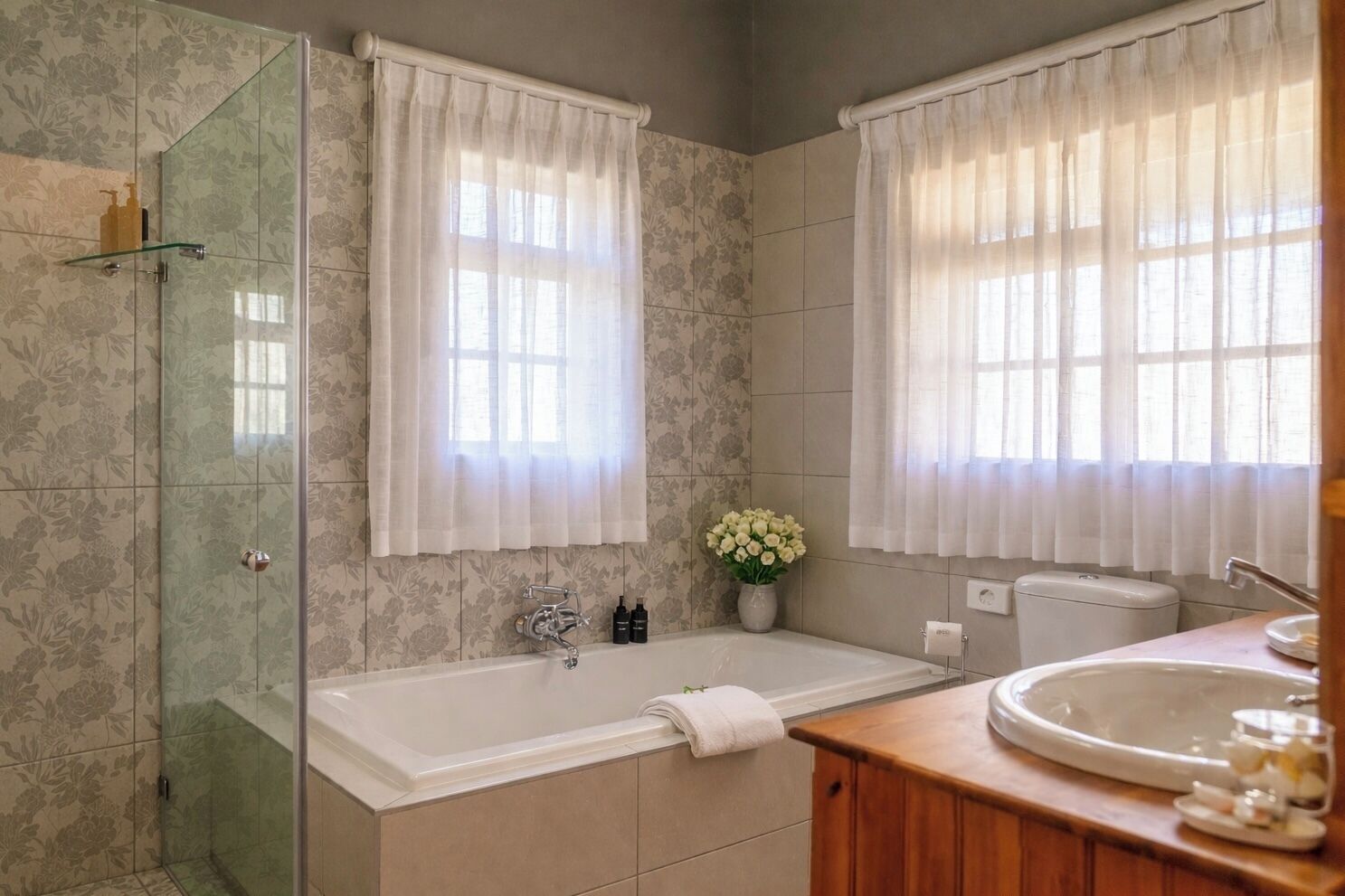 A bathroom with a glass-enclosed shower, a freestanding bathtub, and a vanity with a sink.