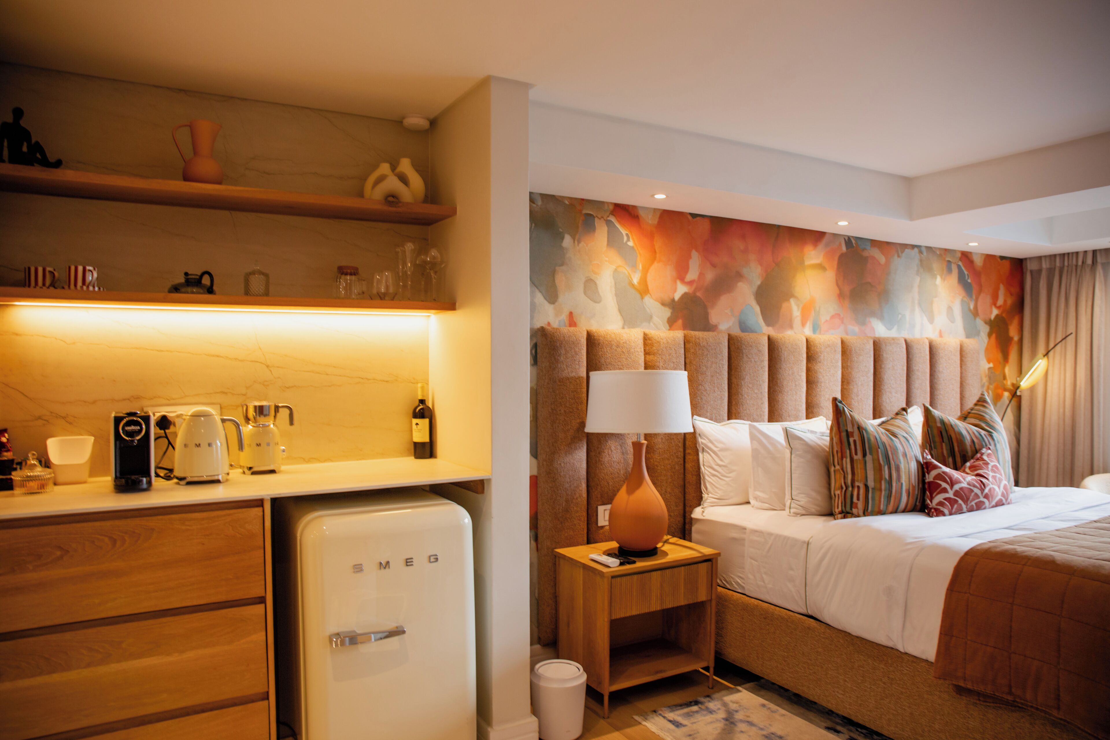 Ein Hotelzimmer mit einem Bett, einem Nachttisch und einer kleinen Küchenzeile.