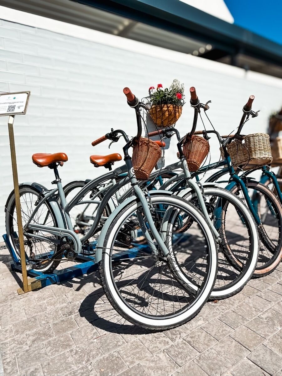 A row of bicycles with baskets and a QR code sign.