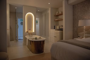 A modern bathroom with a freestanding bathtub, a vanity with a mirror, and a shower area.