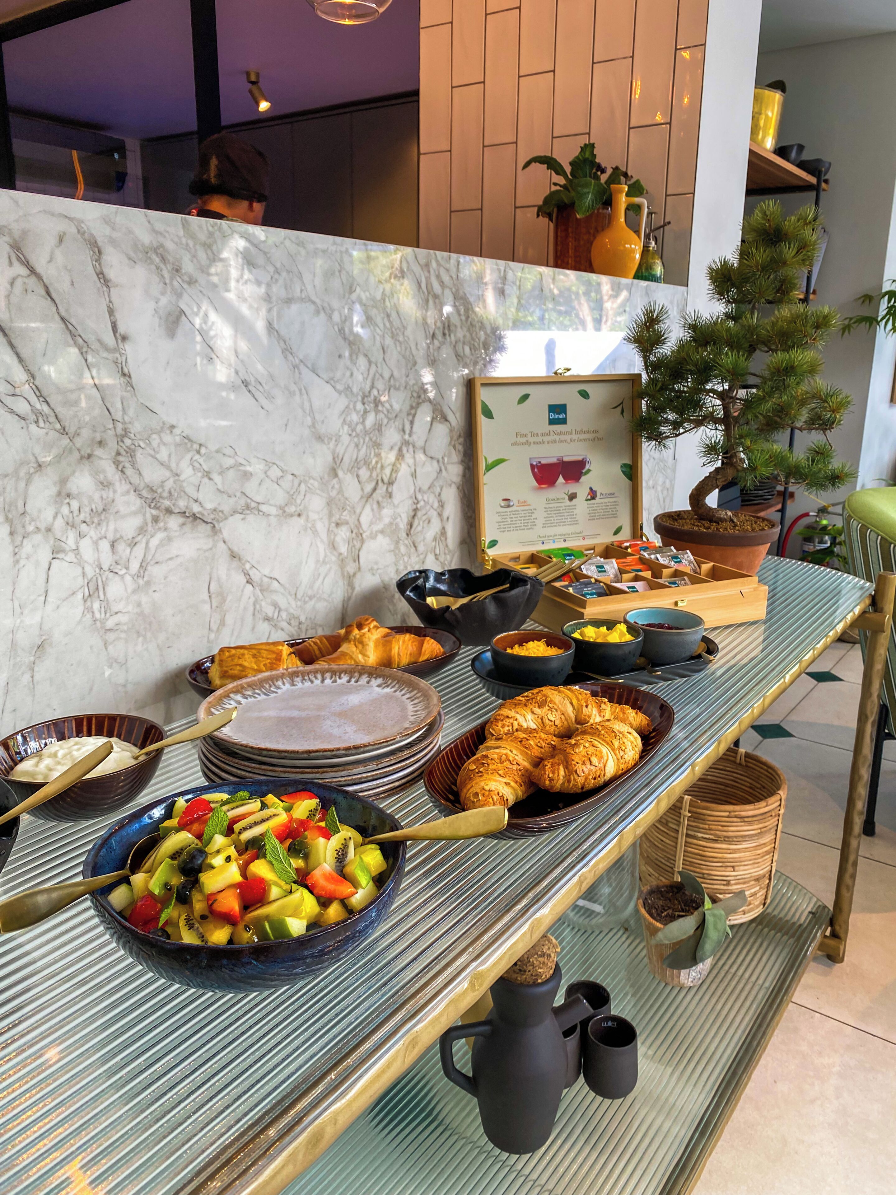A breakfast buffet with various food items and a framed sign.