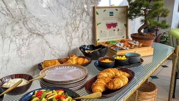 A breakfast buffet with various food items and a framed sign.